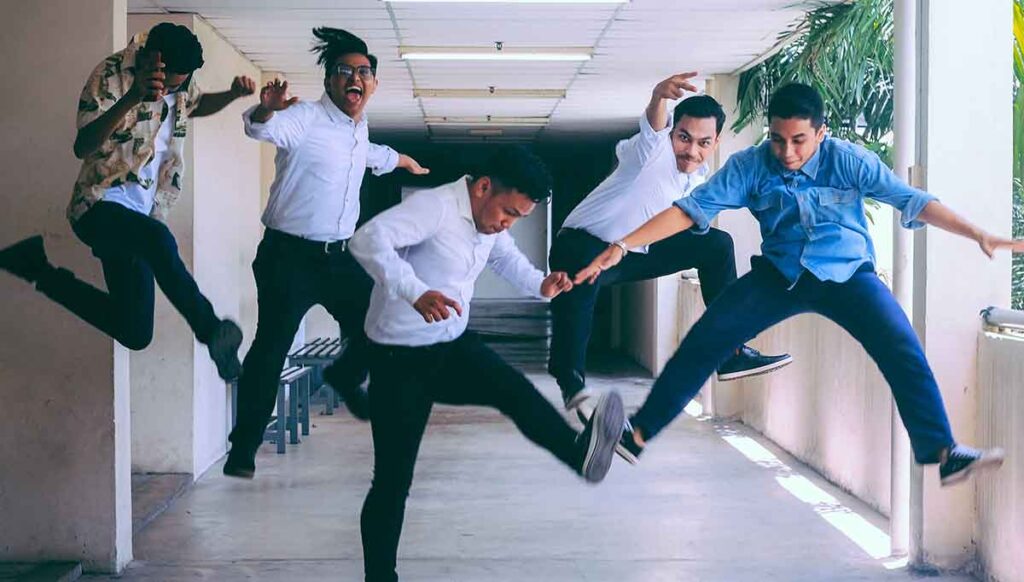 Five men jumping with excitement over making their New Year's resolution getting their medical interpreter certifications.
